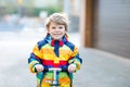 Active school kid boy in colorful casual clothes riding with his scooter in the city Royalty Free Stock Photo