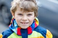 Active school kid boy in colorful casual clothes riding with his scooter in the city Royalty Free Stock Photo