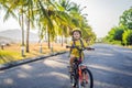 Active school kid boy in safety helmet riding a bike with backpack on sunny day. Happy child biking on way to school