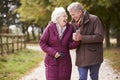 Active Senior Couple On Autumn Walk On Path Through Countryside Royalty Free Stock Photo