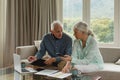 Active senior couple calculating bills in living room Royalty Free Stock Photo