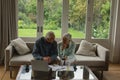 Active senior couple calculating bills in living room Royalty Free Stock Photo
