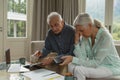 Active senior couple calculating bills in living room Royalty Free Stock Photo