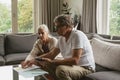 Active senior couple calculating domestic bills on sofa in living room Royalty Free Stock Photo