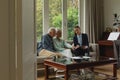 Active senior couple discussing with real estate agent over documents in living room Royalty Free Stock Photo