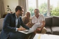 Active senior couple discussing with real estate agent over laptop in living room Royalty Free Stock Photo