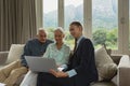 Active senior couple discussing with real estate agent over laptop in living room Royalty Free Stock Photo