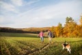 Senior couple with dog on a walk in an autumn nature. Royalty Free Stock Photo