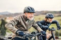 Active senior couple with electrobikes cycling outdoors on a road in nature. Royalty Free Stock Photo