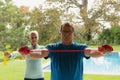 Active senior couple exercising with resistance band in porch at home Royalty Free Stock Photo