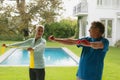 Active senior couple exercising with resistance band in porch at home Royalty Free Stock Photo