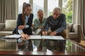 Active senior couple signing an agreement with real estate agent over documents in living room Royalty Free Stock Photo