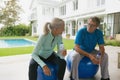 Active senior couple talking with each other after workout in the porch at home