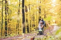 Senior couple with wheelchair in autumn forest.