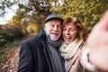 Senior couple in love in an autumn nature, taking selfie. Royalty Free Stock Photo