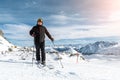 Active senior experienced mature old person in ski helmet, goggles and black suit stand on mountain peak enjoy winter extreme