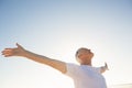 Active senior man with arms outstretched standing against clear sky Royalty Free Stock Photo