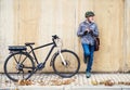 Active senior man with electrobike standing outdoors in town, using smartphone. Royalty Free Stock Photo