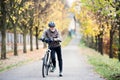 Active senior man with electrobike standing outdoors on a road in nature. Royalty Free Stock Photo