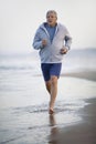 Active senior man jogging along the beach Royalty Free Stock Photo