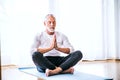 A contented senior man meditating at home. Royalty Free Stock Photo