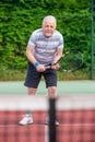 Active senior man playing tennis on the court, sport concept, healthy lifestyle Royalty Free Stock Photo