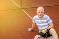 An active senior man playing tennis outside, enjoying pension time, looking happy Royalty Free Stock Photo