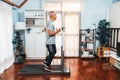 Active senior man running on elliptical running machine. Clout