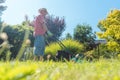 Active senior man smiling while using a grass cutting machine Royalty Free Stock Photo