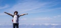 Active senior man standing and enjoying the top of the world opening arms and smiling - blue sky with clouds in background -