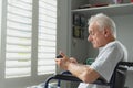 Active senior man in wheelchair using mobile phone at home Royalty Free Stock Photo