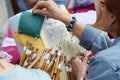 Active senior people workshop with traditional bobbin lace crochet. Hands detail and empty copy space