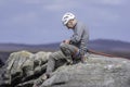 Active senior.Rock climber sitting on cliff edge.