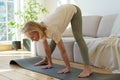 Active healthy senior woman standing in downward facing dog yoga pose while practicing yoga at home Royalty Free Stock Photo