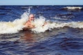 Active senior swims in sea waves Royalty Free Stock Photo
