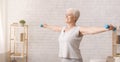 Active senior woman doing exercises with dumbbells at home Royalty Free Stock Photo