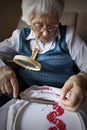 Active senior woman embroidering