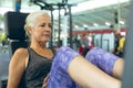 Active senior woman exercising with leg press machine in fitness studio Royalty Free Stock Photo