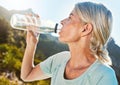 Active senior woman out for a run or jog in nature and drinking water while taking a break. Living active and healthy Royalty Free Stock Photo