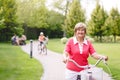 Active senior woman riding bike in a park Royalty Free Stock Photo