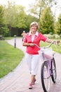 Active senior woman riding bike in a park Royalty Free Stock Photo