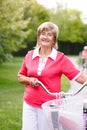 Active senior woman riding bike in a park Royalty Free Stock Photo