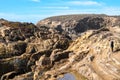 Active senior woman stands on the slippery rocks of Point Lobos State Reserve in California, admiring the scenery