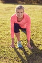 Active senior woman stretching on grass in morning sunlight Royalty Free Stock Photo