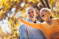 Seniors taking selfies of them having fun outside in the autumn forest Royalty Free Stock Photo