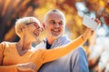 Seniors taking selfies of them having fun outside in the autumn forest Royalty Free Stock Photo