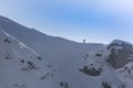 active skier in red with a backpack on a winter trail among a snow covered spruce treesin the middle of the mountain range Royalty Free Stock Photo