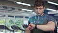 Active sport man in the gym check health indicator and heart rate on smartwatch. Future technology concept of humanity