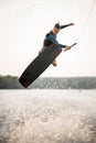active sportsman jumps spectacularly on wakeboard above the water with splashes Royalty Free Stock Photo