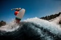 Active sporty guy jumping on wave on surf style wakeboard Royalty Free Stock Photo